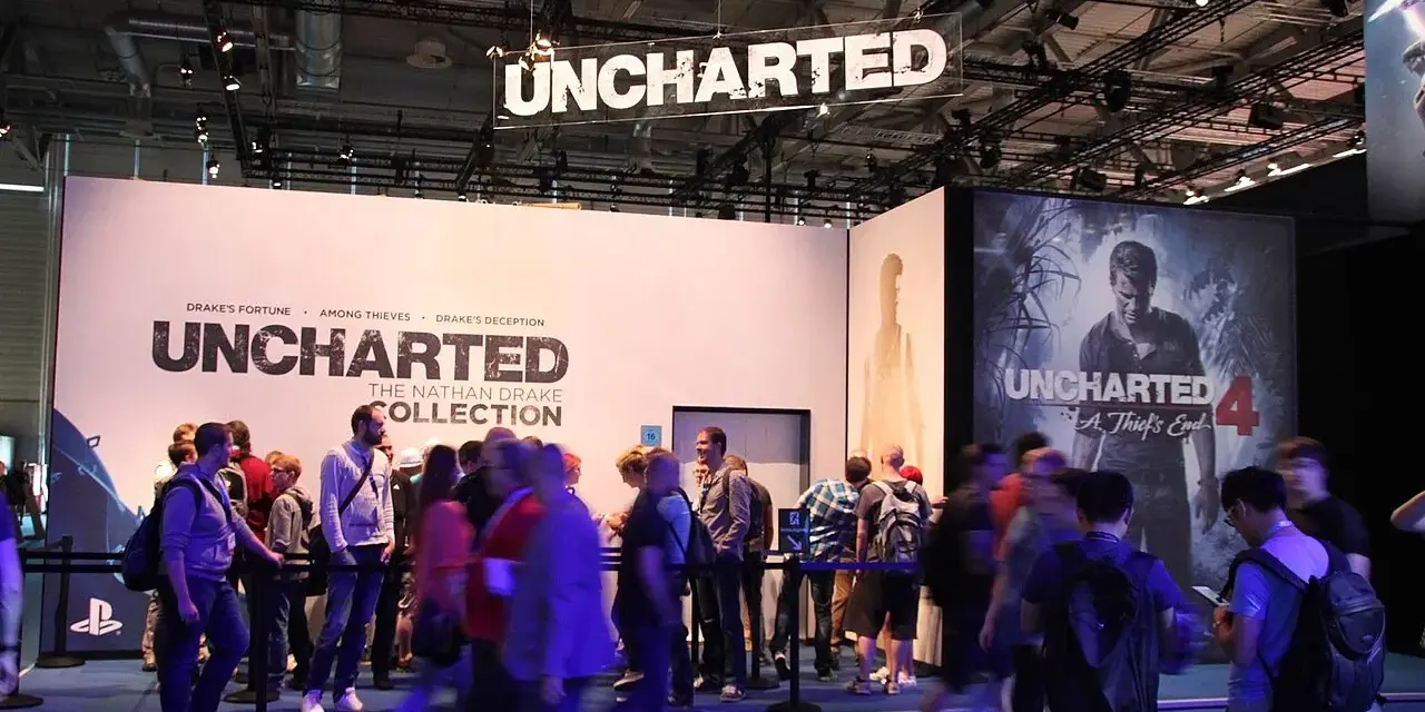 Gente en un evento de videojuegos, con carteles de Uncharted 4 y The Nathan Drake Collection. Se ven varios capítulos de Uncharted.