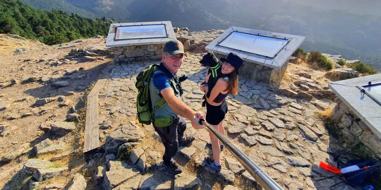 Pareja y perro posan en la barranca mirador de las canchas, disfrutando de las vistas montañosas.