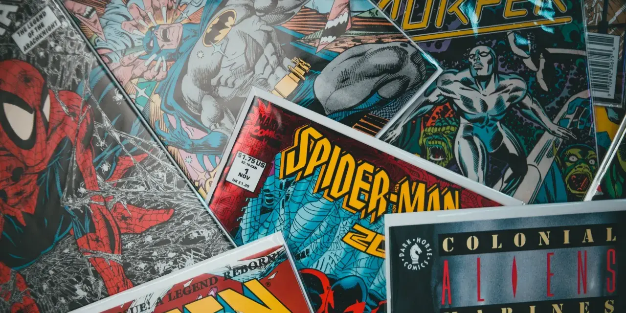 Stos komiksów z postaciami takimi jak Spider-Man, Batman i Silver Surfer. Czy komiks to książka? To zależy od tego, jak na to spojrzeć!