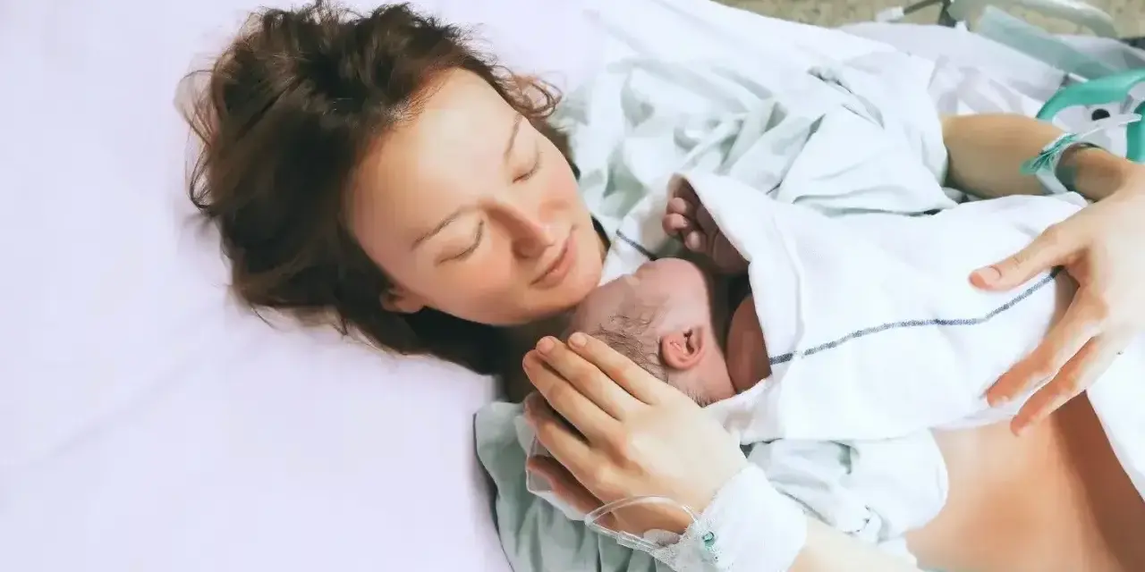 Mama tuli dziecko na rękach, szczęśliwa po 39 tygodniu ciąży.