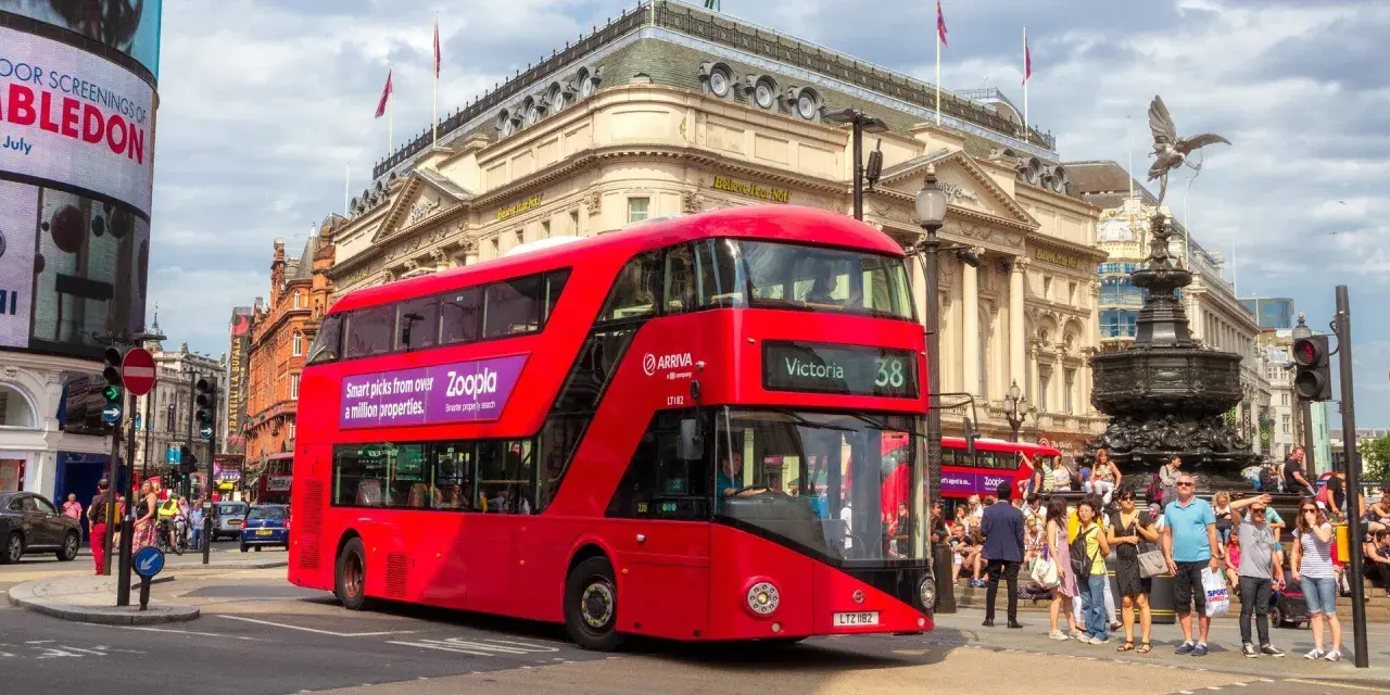 Czerwony piętrowy autobus w Londynie na tle Piccadilly Circus.