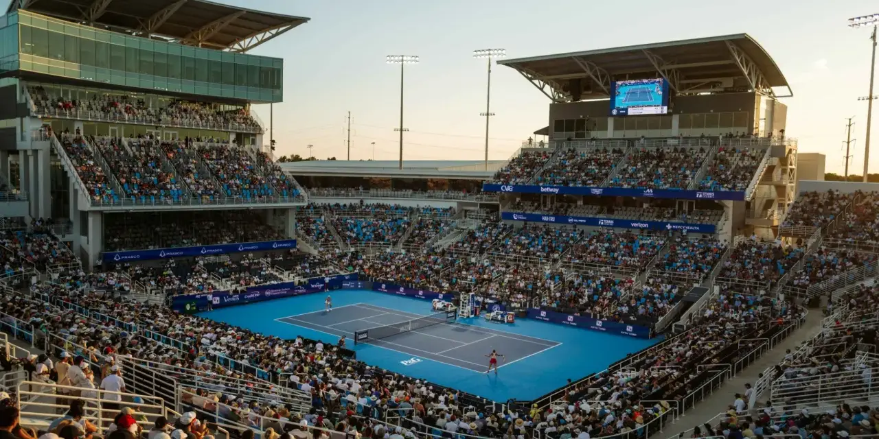Un partido de tenis en el torneo de Cincinnati, con gradas llenas de espectadores bajo un cielo despejado.