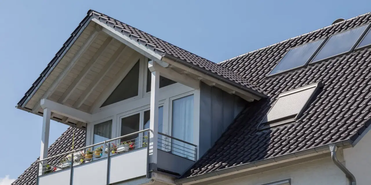 Dachgaube mit Balkon und Solarpaneelen. Informieren Sie sich über Dachgaube Kosten für Ihr Zuhause.