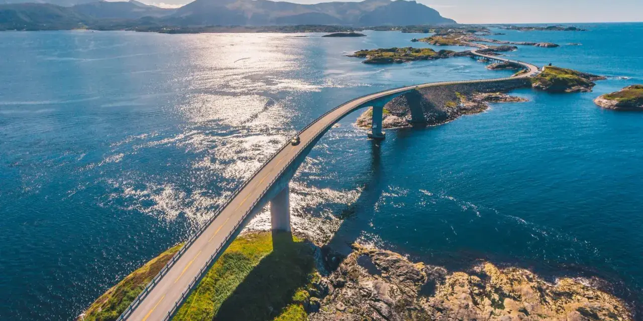 En bil kör över en bro i Norge, en del av den fantastiska Atlantvägen. En dröm att åka till Norge och uppleva detta!