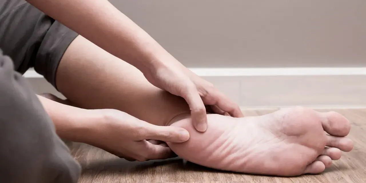 Person känner efter smärta i foten, som om det vore en spik i skon.