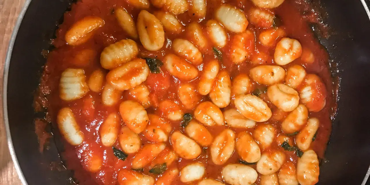 Pyszne gnocchi w aromatycznym sosie pomidorowym z ziołami, gotowe do podania. Idealny sos do gnocchi na szybki obiad.