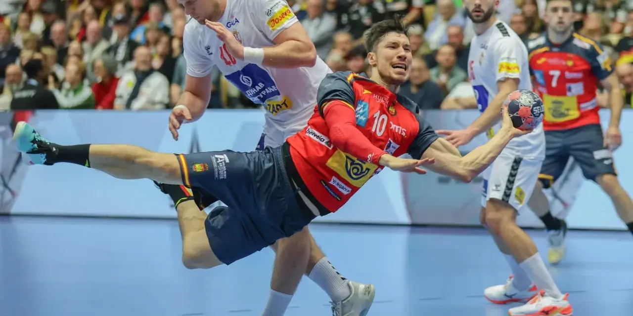Piłkarz ręczny Hiszpanii w czerwonej koszulce z numerem 10 wykonuje rzut. W tle inny zawodnik i kibice.