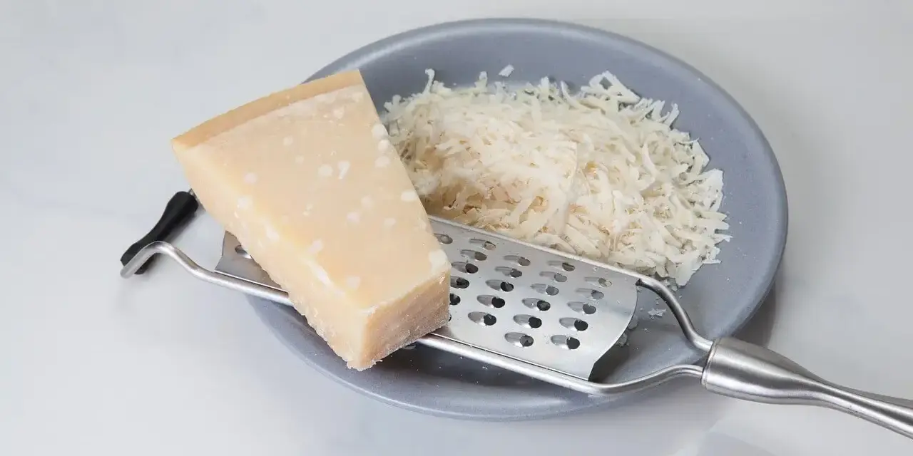 Kawałek sera i tarka na talerzu. Szukasz, czym zastąpić parmezan? Oto inspiracja!