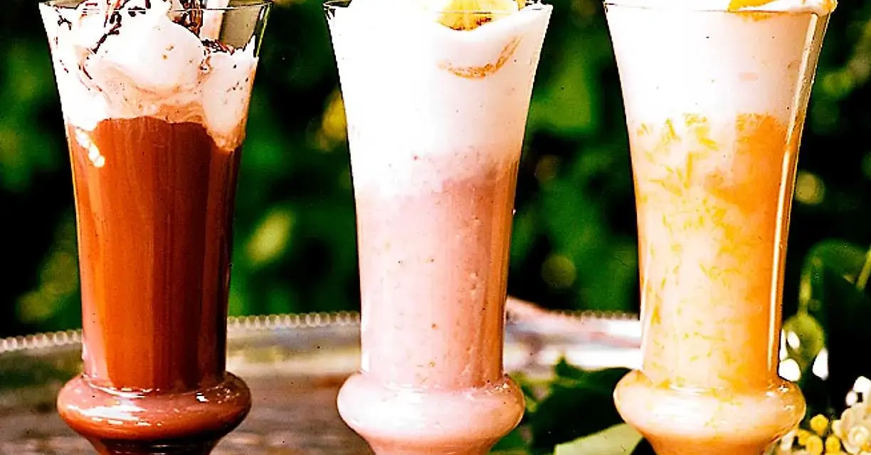 Tre läckra milkshakes i glas: choklad, jordgubb och aprikos. Perfekt för ett somrigt milkshake recept.