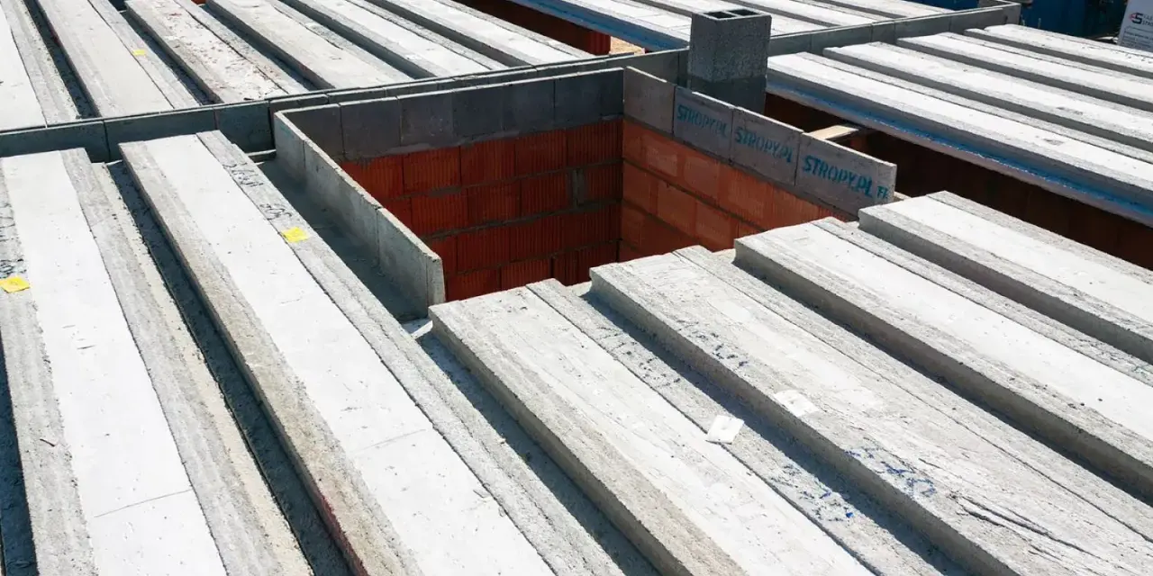 Strop panelowy smart cena za m2. Betonowe belki stropowe ułożone na budowie, gotowe do montażu.