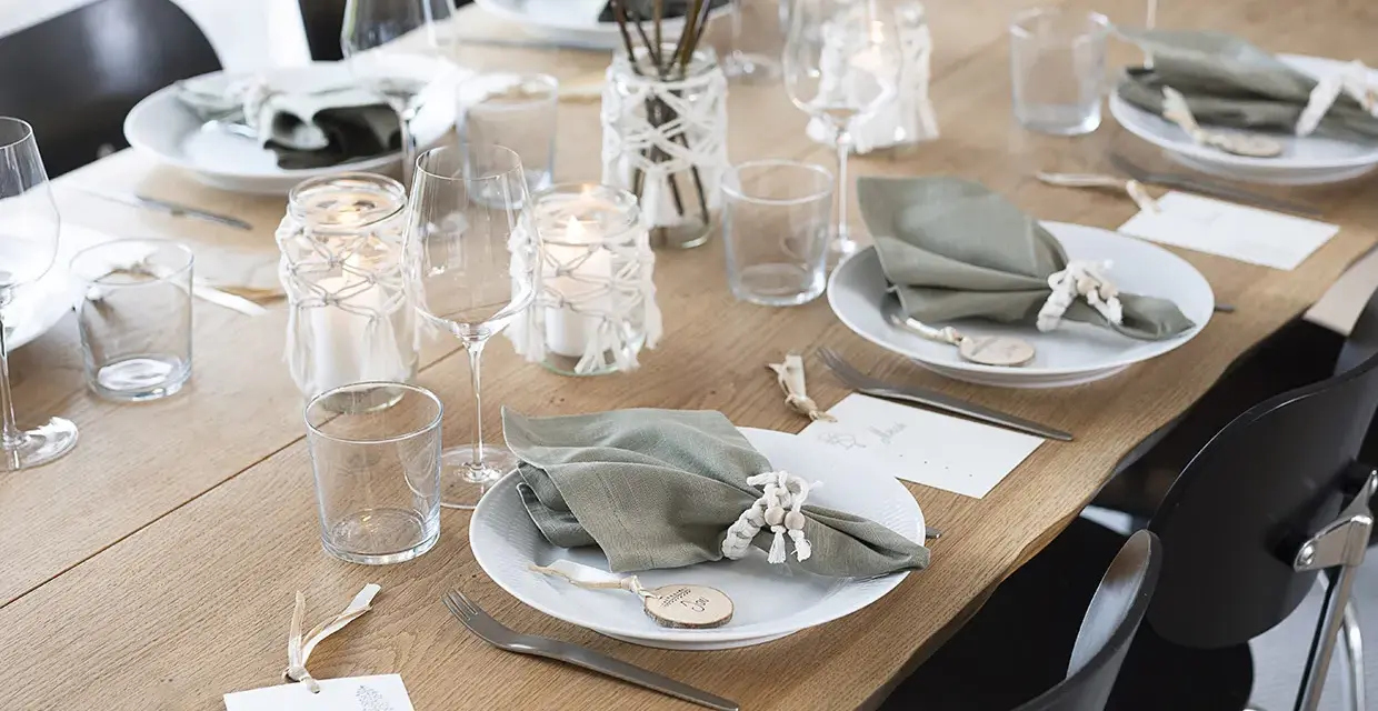 Vacker dukning med gröna servetter, ljus och blommor. Perfekt fest dekoration inspiration för ett stilrent hem.