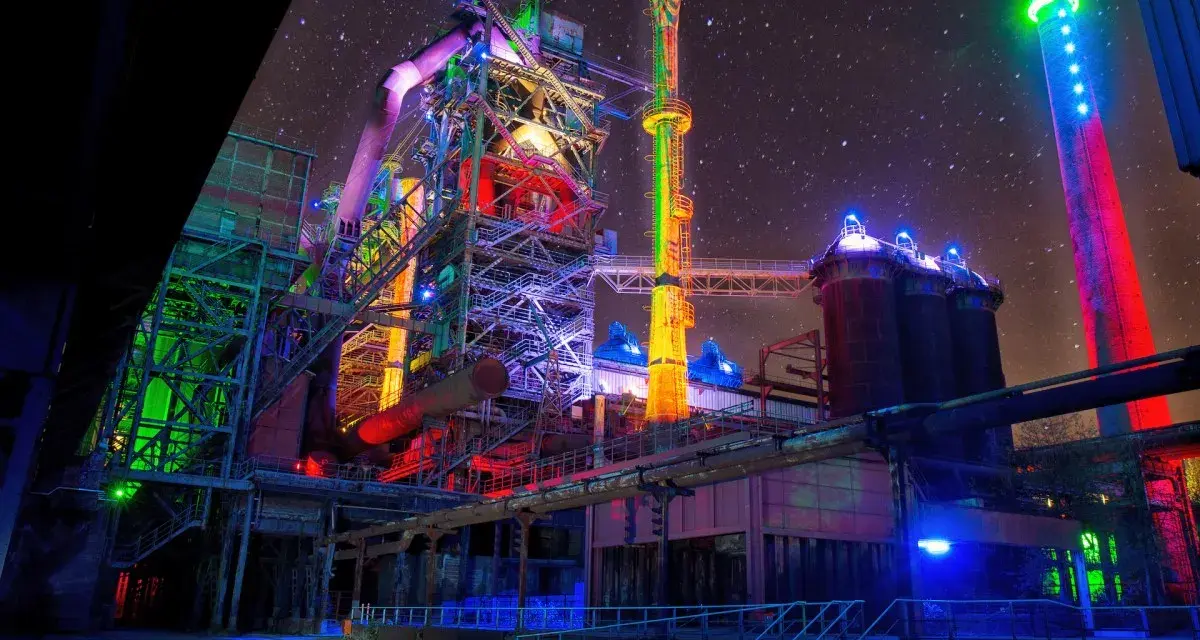 Industrielles Lichterspiel im Landschaftspark Duisburg unter sternklarem Himmel. Bunte Beleuchtung verwandelt die Stahlriesen in ein Kunstwerk.