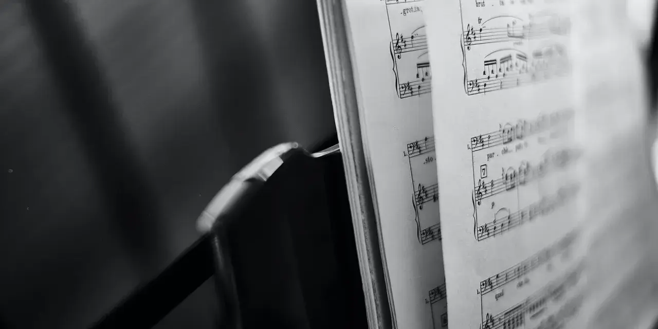 Spartito musicale aperto, con note e indicazioni di tempo, evoca le grandi colonne sonore che hanno segnato cinema e TV.