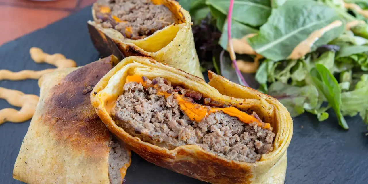Herzhafte Burger Wraps mit geschmolzenem Käse und einem Beilagensalat.