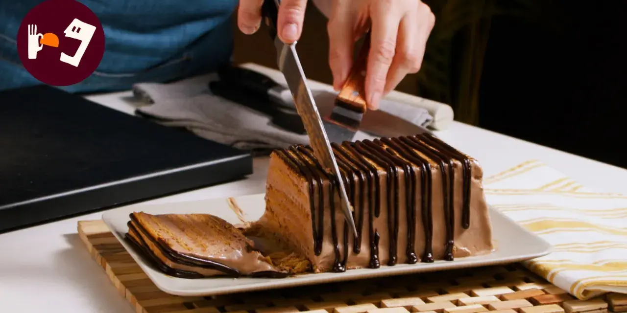 Cortando una porción de la deliciosa tarta de queso casera de la abuela, cubierta con chocolate.