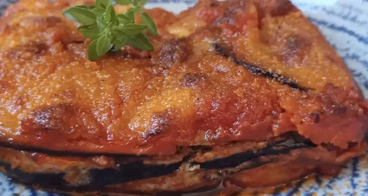 Parmigiana in padella, uno strato di melanzane fritte, pomodoro e formaggio, guarnita con basilico fresco.