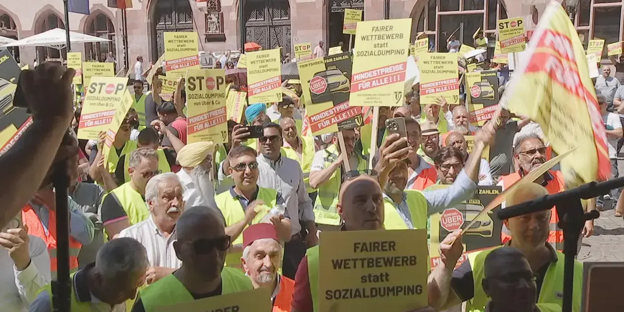 Demonstranten mit gelben Schildern fordern "Fairer Wettbewerb statt Sozialdumping" und "Mindestpreise für alle". Ein **Taxi-Streik** ist im Gange.