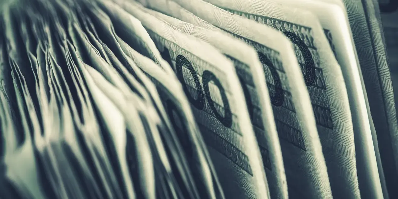 Zbliżenie na banknoty 100 zł. Widoczne detale i wzory, sugerujące zgromadzone środki, być może jako konto depozytowe osadzonego.