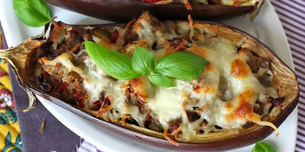 Melanzane ripiene al forno velocissime, dorate e filanti, guarnite con basilico fresco. Un piatto invitante e facile da preparare.