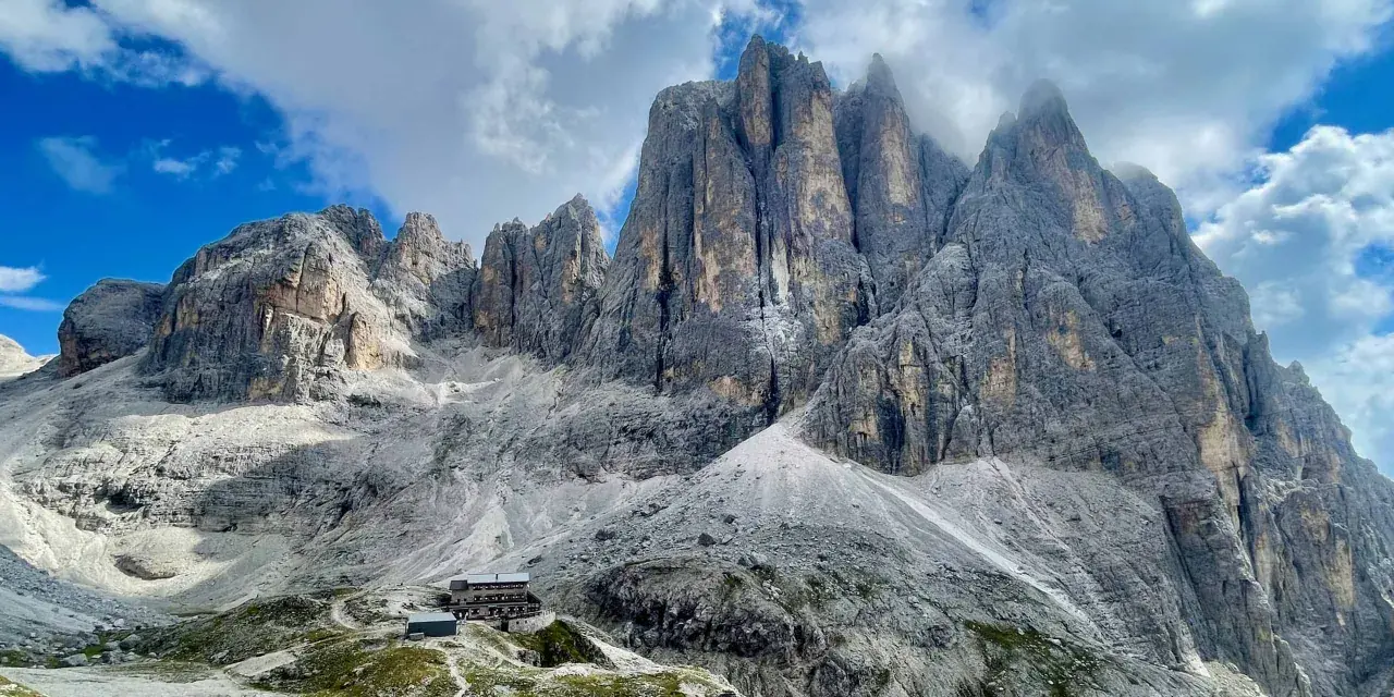 Rifugio alpino ai piedi di imponenti vette dolomitiche, ideale per un trekking di 5 giorni.