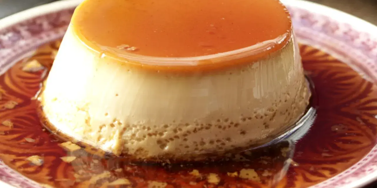 Delicioso flan de café con caramelo líquido, servido en un plato con un diseño intrincado.