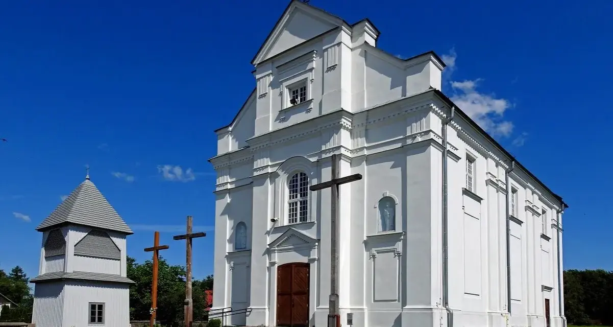 Biały kościół z dzwonnicą i krzyżami. Darowizna na cele kultu religijnego wspiera takie miejsca.