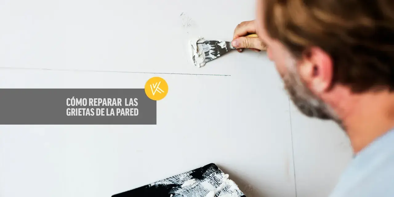 Hombre repara grietas en pared con aguaplast. Aprende por qué se agrieta el aguaplast y cómo solucionarlo.