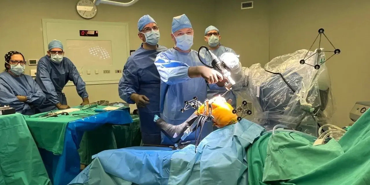 Zespół chirurgów w sali operacyjnej podczas zabiegu ortopedycznego z użyciem robota.