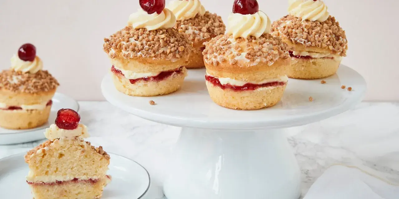Frankfurter Kranz Muffins: kleine Kuchen mit Buttercreme, Marmelade und Mandelsplittern, gekrönt von einer Kirsche.