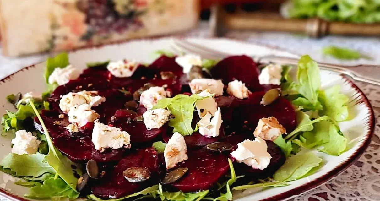 Pyszne carpaccio z buraka z serem feta i pestkami dyni na talerzu.