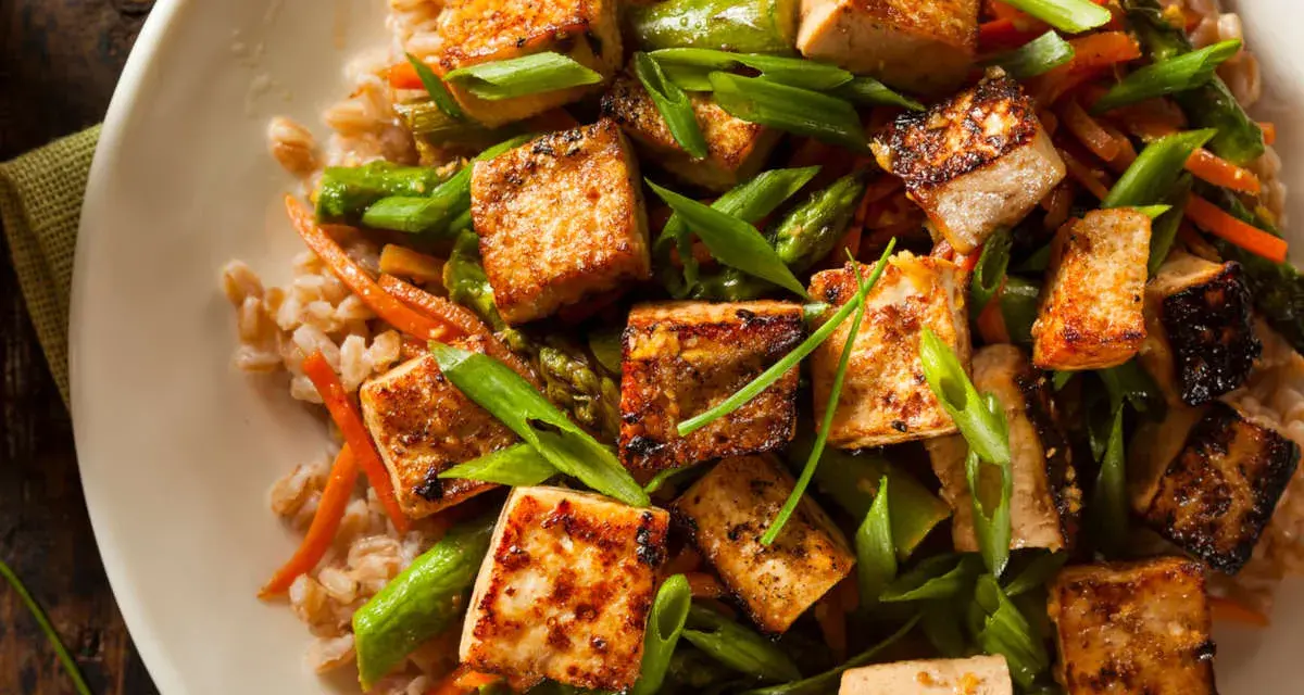 Chrupiące kostki tofu z warzywami i kaszą. Tofu to wszechstronny produkt roślinny, idealny do dań azjatyckich.
