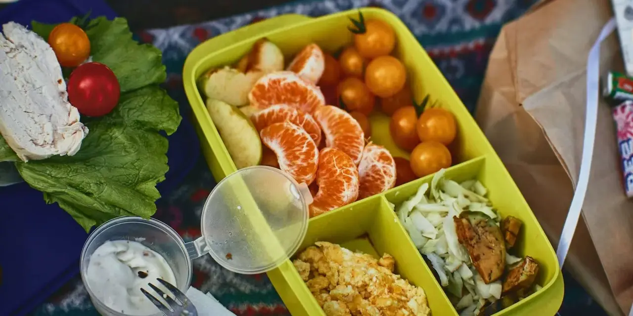 Piknikowy lunch: kurczak, pomidorki, mandarynki, jajecznica i surówka. Czy można wziąć jedzenie do samolotu Ryanair? Takie posiłki są idealne na podróż.