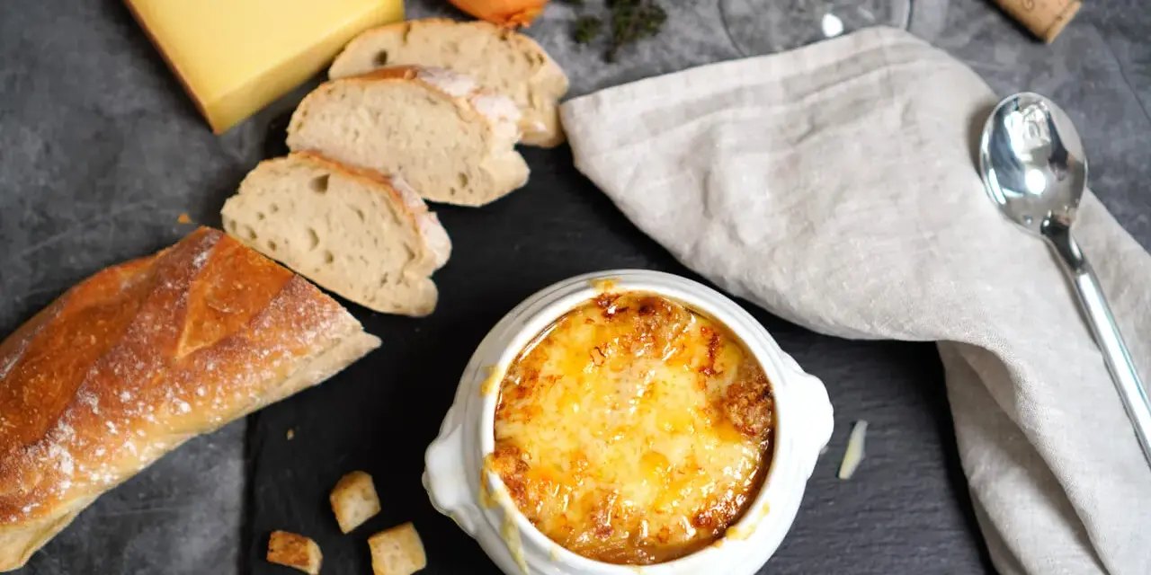 Herzhaftes Zwiebelsuppen-Rezept: goldbraun überbackene Suppe mit Käse, Baguette und Zwiebeln.