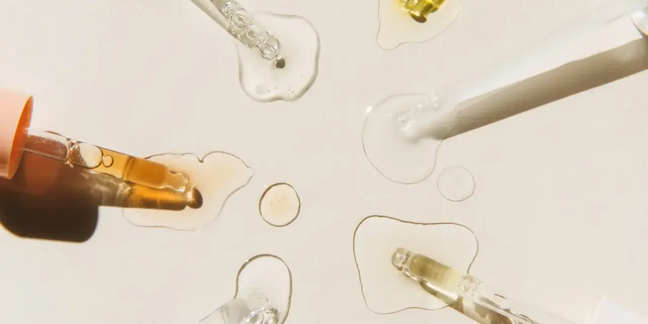 Krople serum i pipetki na jasnym tle.