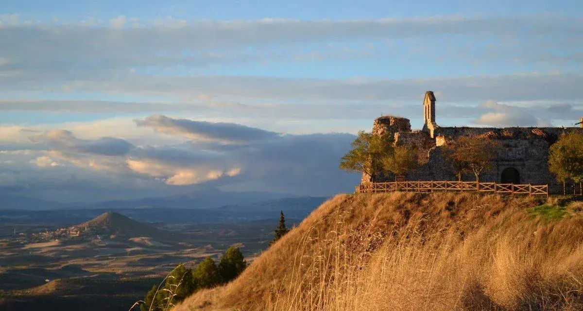 Ruinas de un castillo en un cerro, con un paisaje de la Alcarria al fondo. El mirador ofrece vistas espectaculares.