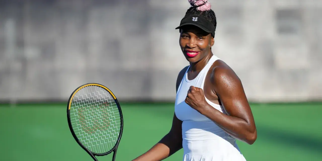 Venus Williams, con su estatura imponente, celebra un punto en la cancha de tenis.
