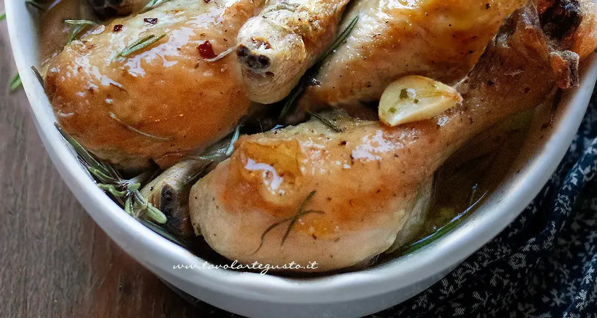 Succulente cosce di pollo al forno, dorate e profumate al rosmarino e aglio, servite in una ciotola bianca.