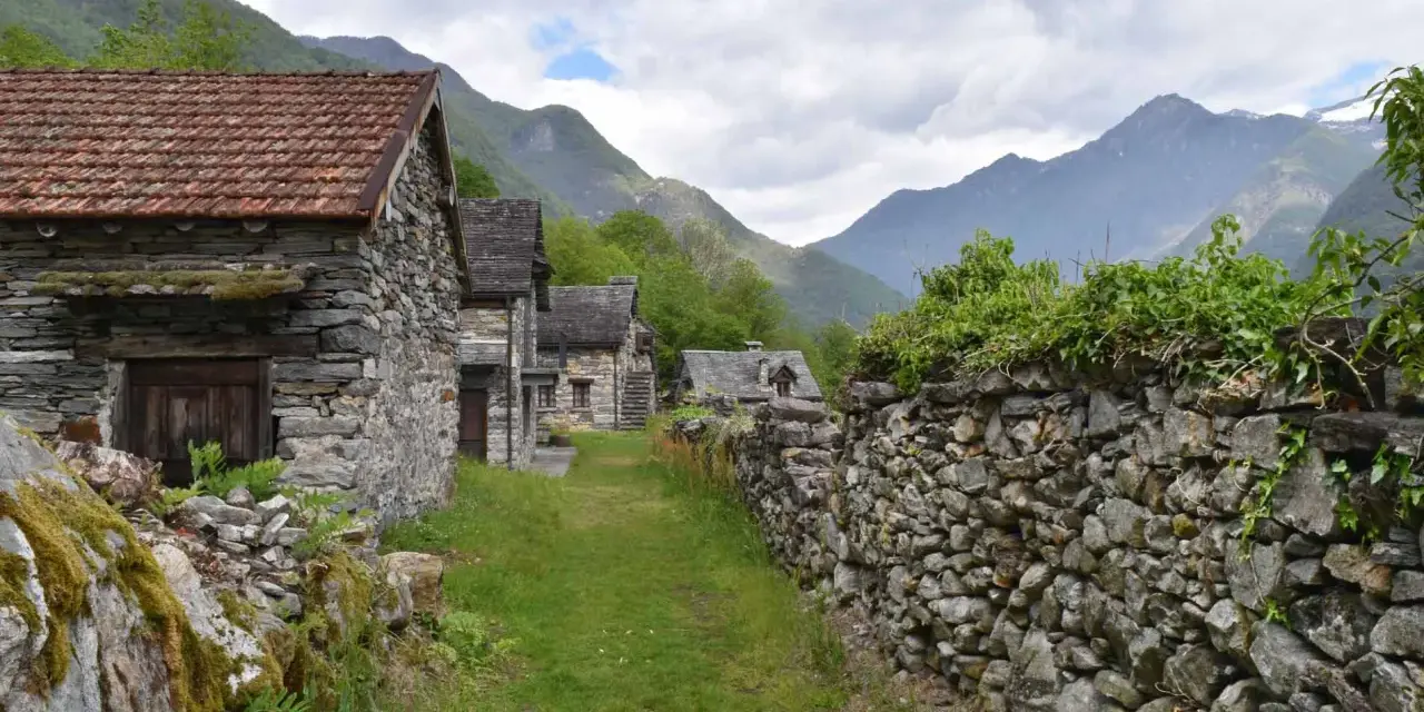 Steindörfer im Valle Maggia, umgeben von grünen Bergen und bewachsenen Mauern.