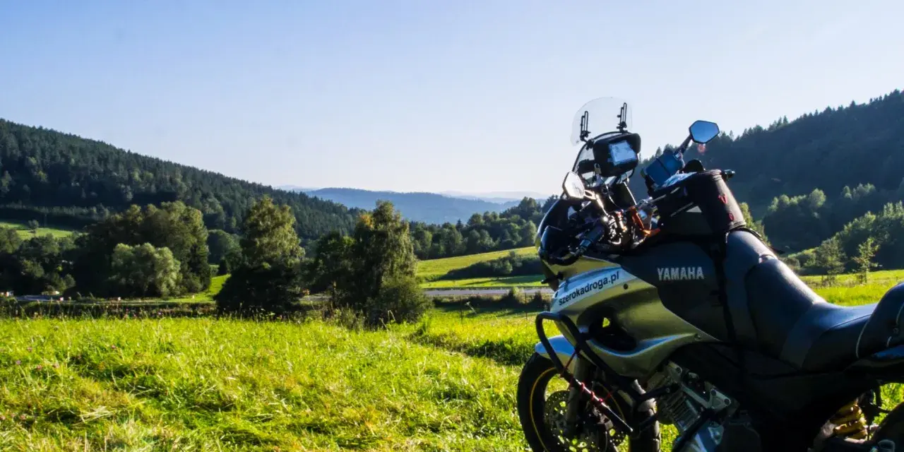 Motocykl Yamaha zaparkowany na łące, w tle malownicze wzgórza Bieszczad. Idealne miejsce na przejażdżkę pętlą bieszczadzką.