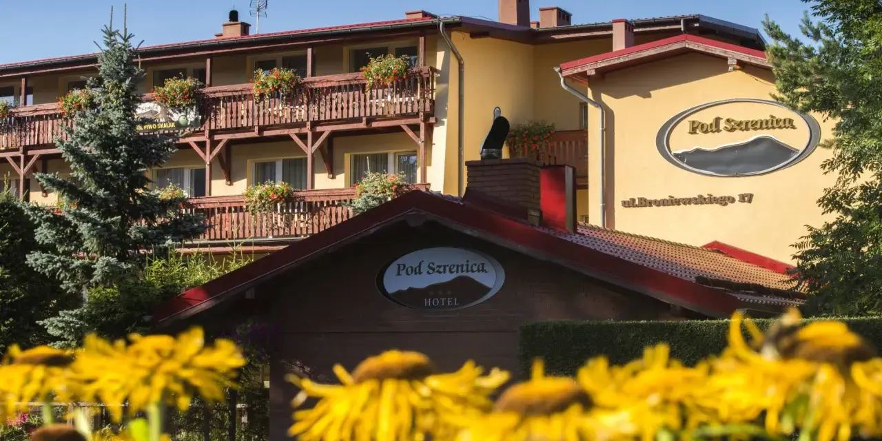 Hotel Pod Szrenicą w Szklarskiej Porębie, otoczony zielenią i kwitnącymi kwiatami, zaprasza na wypoczynek.