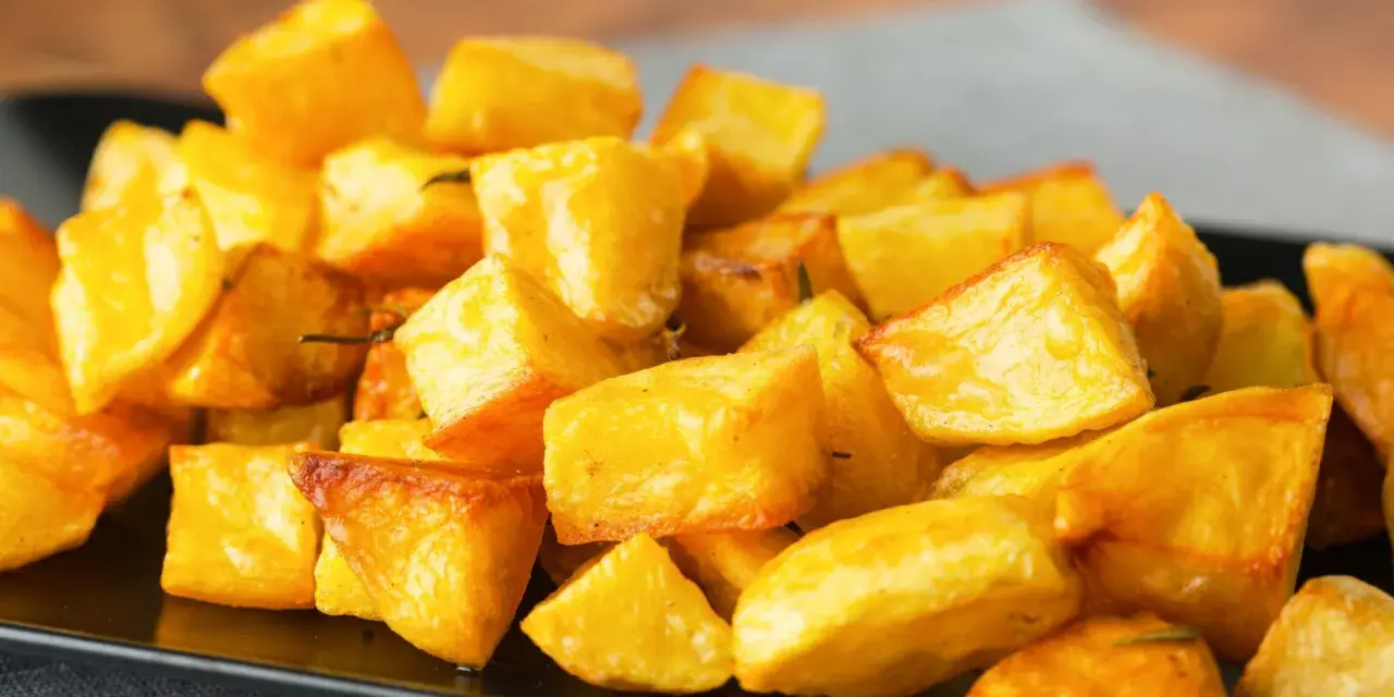 Un mucchio invitante di patate al forno croccanti, dorate e profumate, pronte per essere gustate.