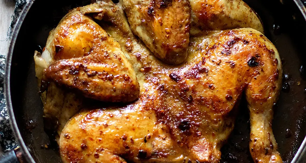 Pollo alla diavola dorato e succulento, cotto in padella con spezie piccanti.
