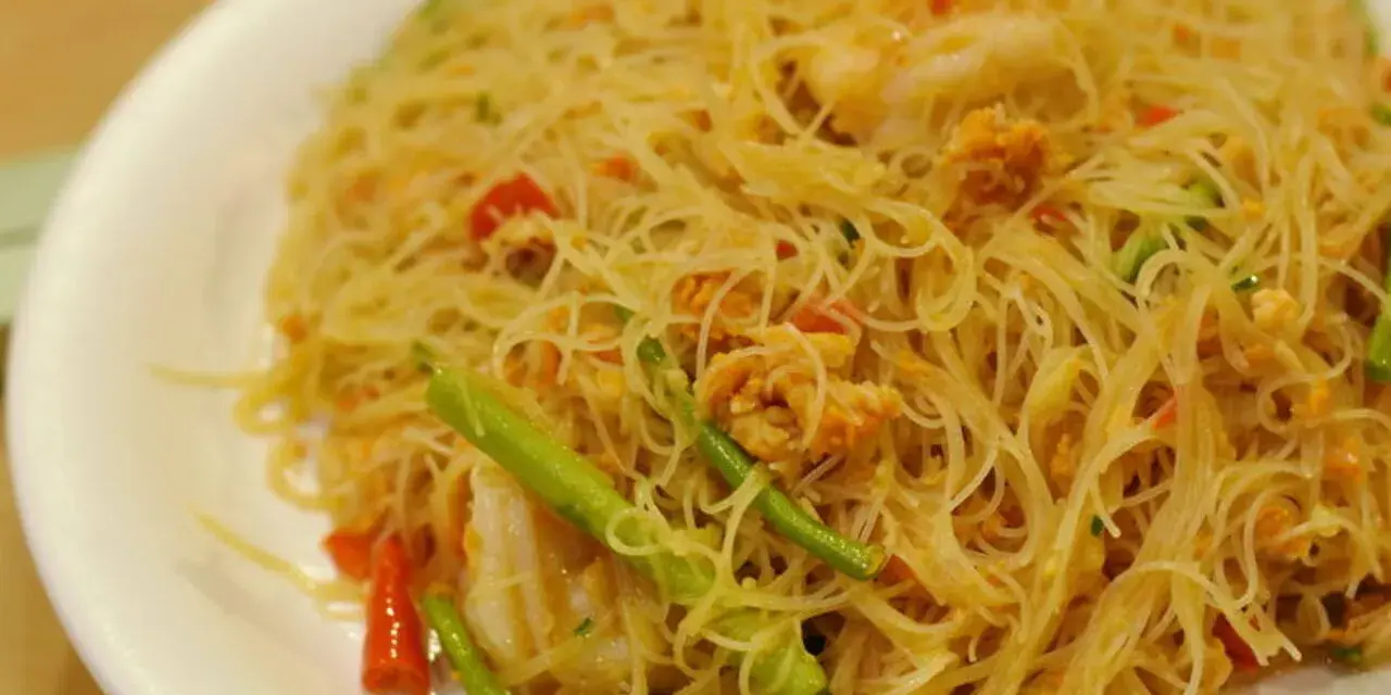 Pyszne danie z cienkim makaronem, przypominającym vermicelli czy capellini, z kawałkami krewetek i zielonych warzyw.