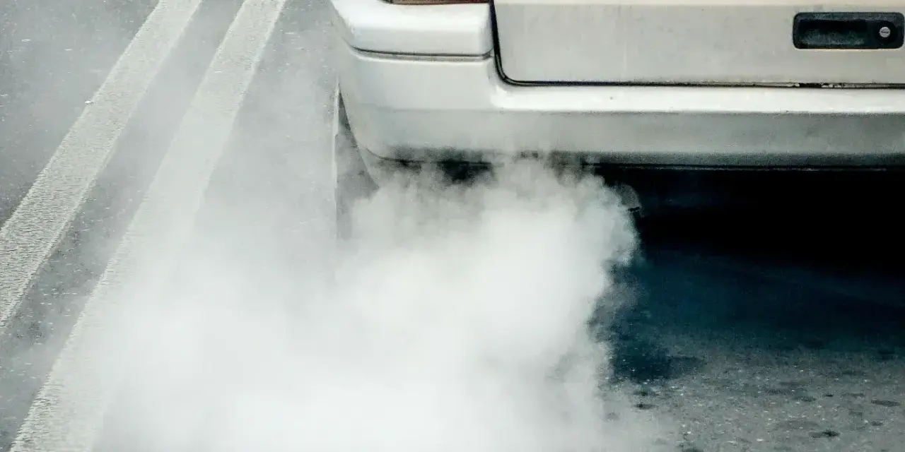 Z tyłu samochodu wydobywa się biały dym. Widać fragment tylnej lampy i tablicy rejestracyjnej. Diesel kopci na biało.