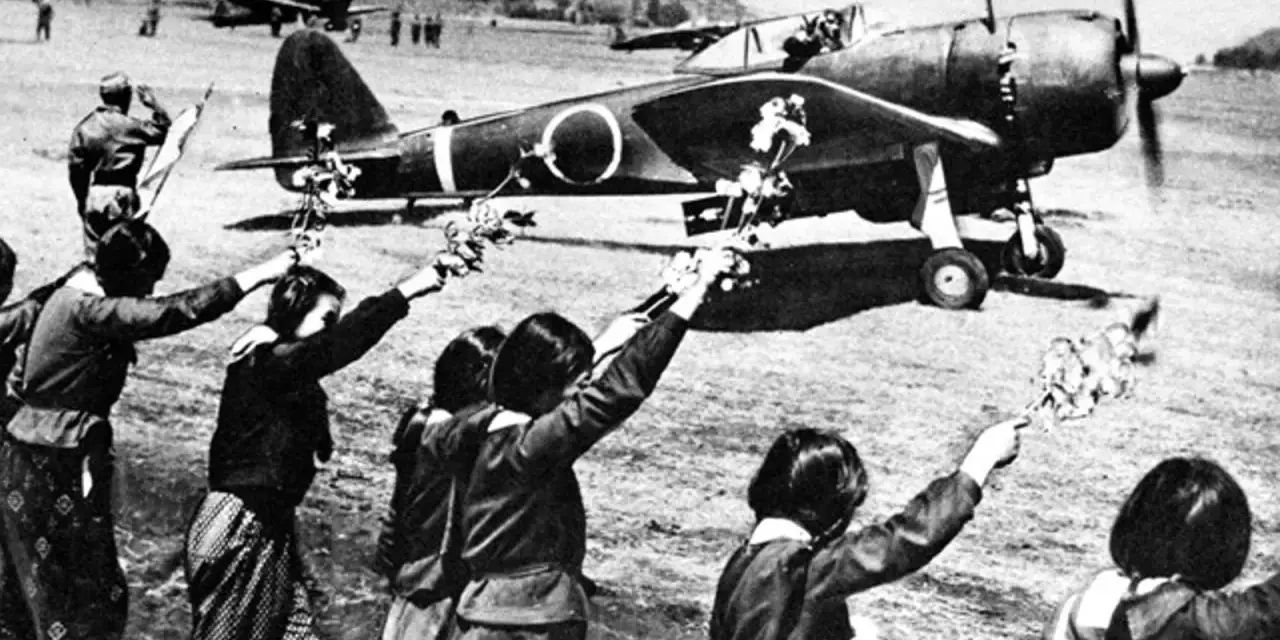 Des jeunes Japonais agitent des fleurs vers un avion, peut-être un adieu avant une mission kamikaze.