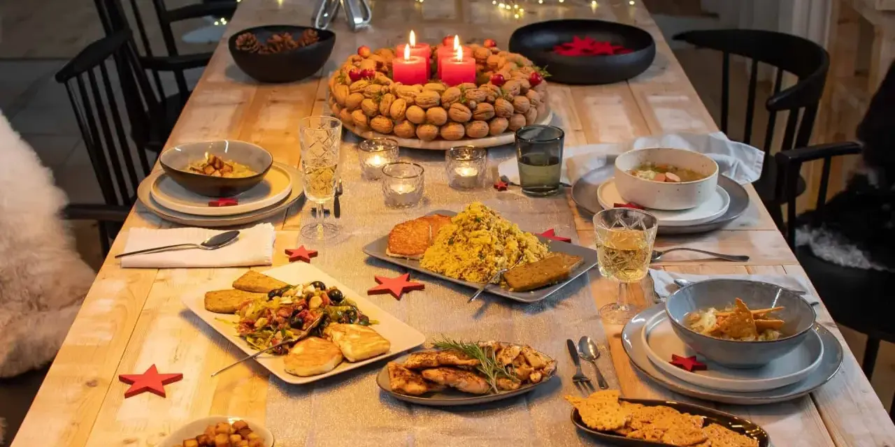 Festlich gedeckter Tisch mit leckerem Essen, bereit für das weihnachtsessen einen tag vorher vorbereiten. Kerzen brennen, Nüsse und Tannenzapfen schmücken.