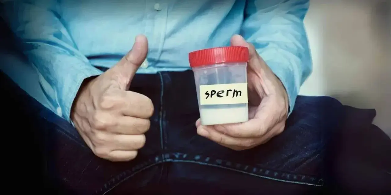 Mężczyzna pokazuje kciuk w górę, trzymając pojemnik z napisem "sperm". Zawartość pojemnika ma prawidłowy kolor spermy.