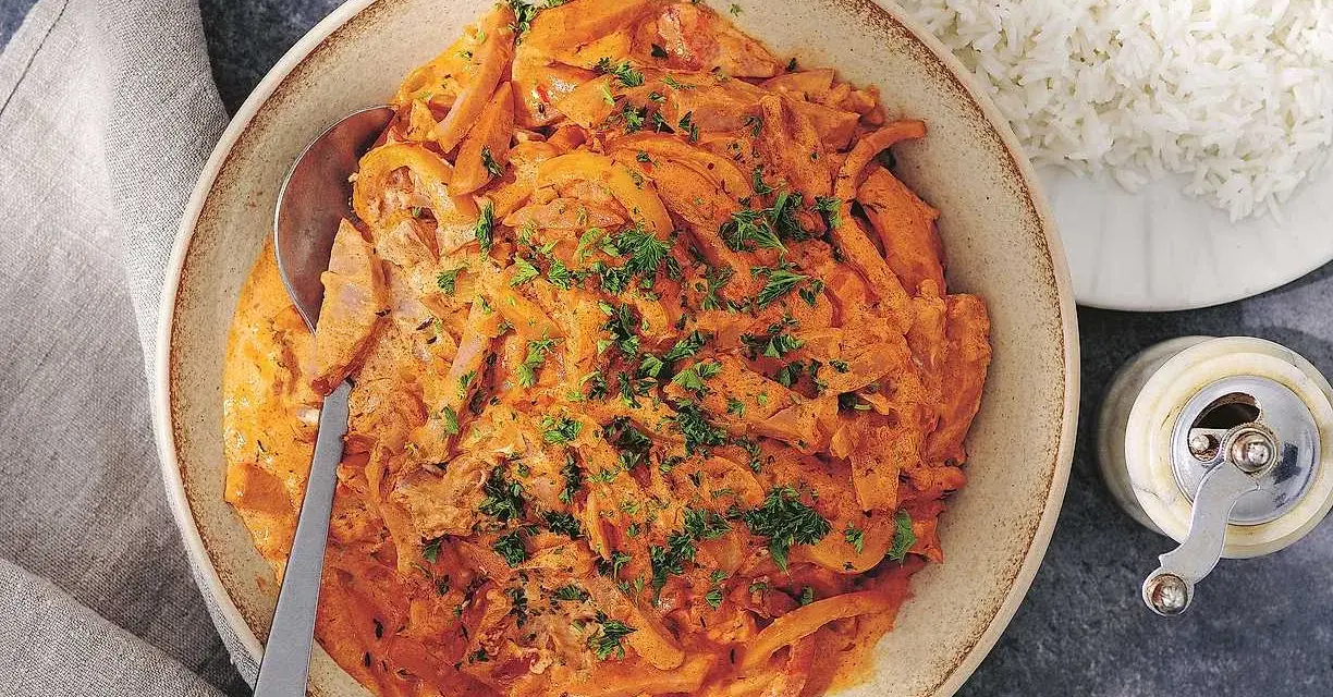 En krämig korvgryta, perfekt för ett snabbt och gott korvgryta recept. Serveras med fluffigt ris och toppas med färsk persilja.