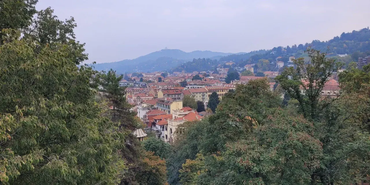 Vue panoramique de Turin, avec ses toits rouges et ses collines verdoyantes. Idéal pour savoir que faire à Turin avec des enfants, entre parcs et musées.
