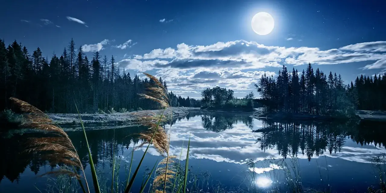 Paysage nocturne féerique, lac paisible reflétant la lune et les nuages. Une retouche photo paysage Photoshop qui sublime la nature.